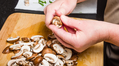 cook-slicing-mushrooms-in-kitchen.jpg