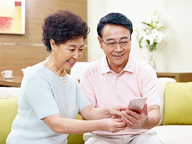 Senior asian couple using a cellphone together