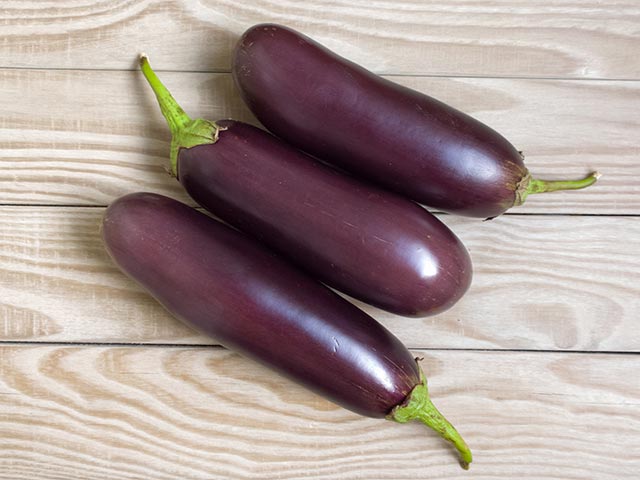 top-down shot of 3 brinjals on a table next to each other