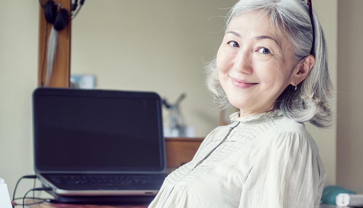 asian-senior-woman-leaned-back-in-her-chair-and-smiling.jpg