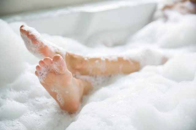 woman's feet in bubble bath