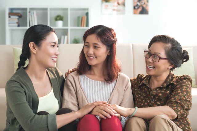 three generations of asian family women sitting together