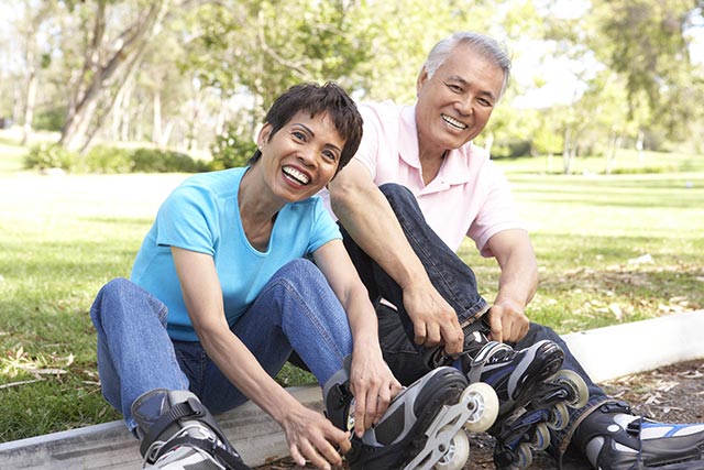 Elderly couple spending time together learning to rollerblade