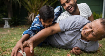 Three generational family having fun playing a game of catch