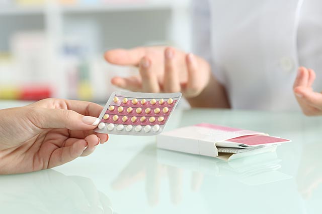 Asian woman buying contraceptives from a pharmacy