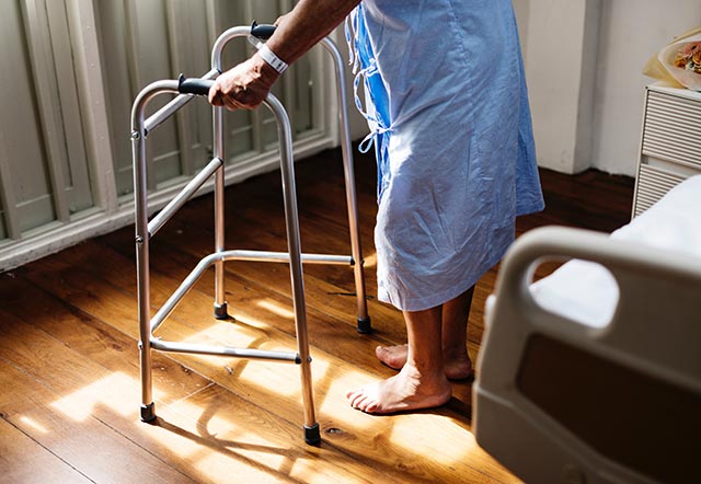 Fall patient using a walking frame to move about in the ward
