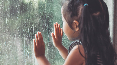sad-asian-little-girl-looking-outside-through-the-window-in-the-rainy-day.jpg
