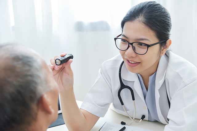 Doctor checking a senior patient's eyes