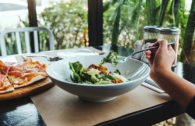 Portions of Ceasar Salad and Pizza