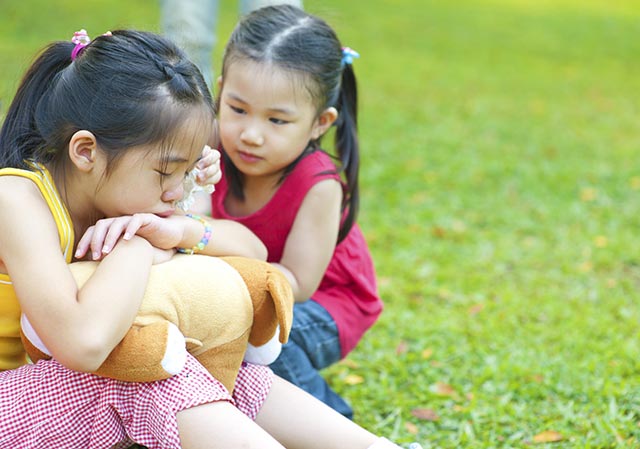 a young chinese child consoling her friend