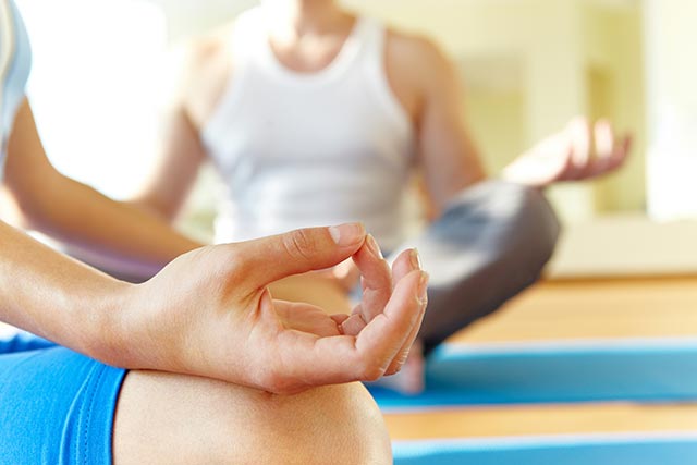 A woman practicing deep breathing in yoga class