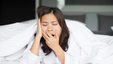 Young woman yawning, perhaps a sign of sleep problems.