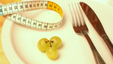 measuring tape and 3 green grapes on a plate