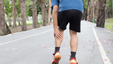 A senior man experiencing leg cramps in the middle of a run