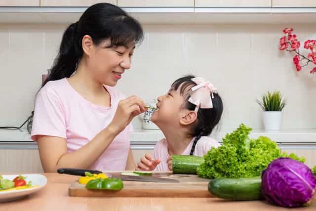 Mum teaching her 3-year-old about healthy eating and nutrition.