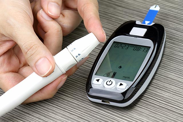 Person with diabetes taking her blood glucose readings