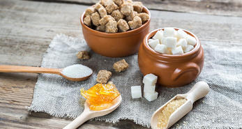 Different types and forms of sugar on display on a textured cloth